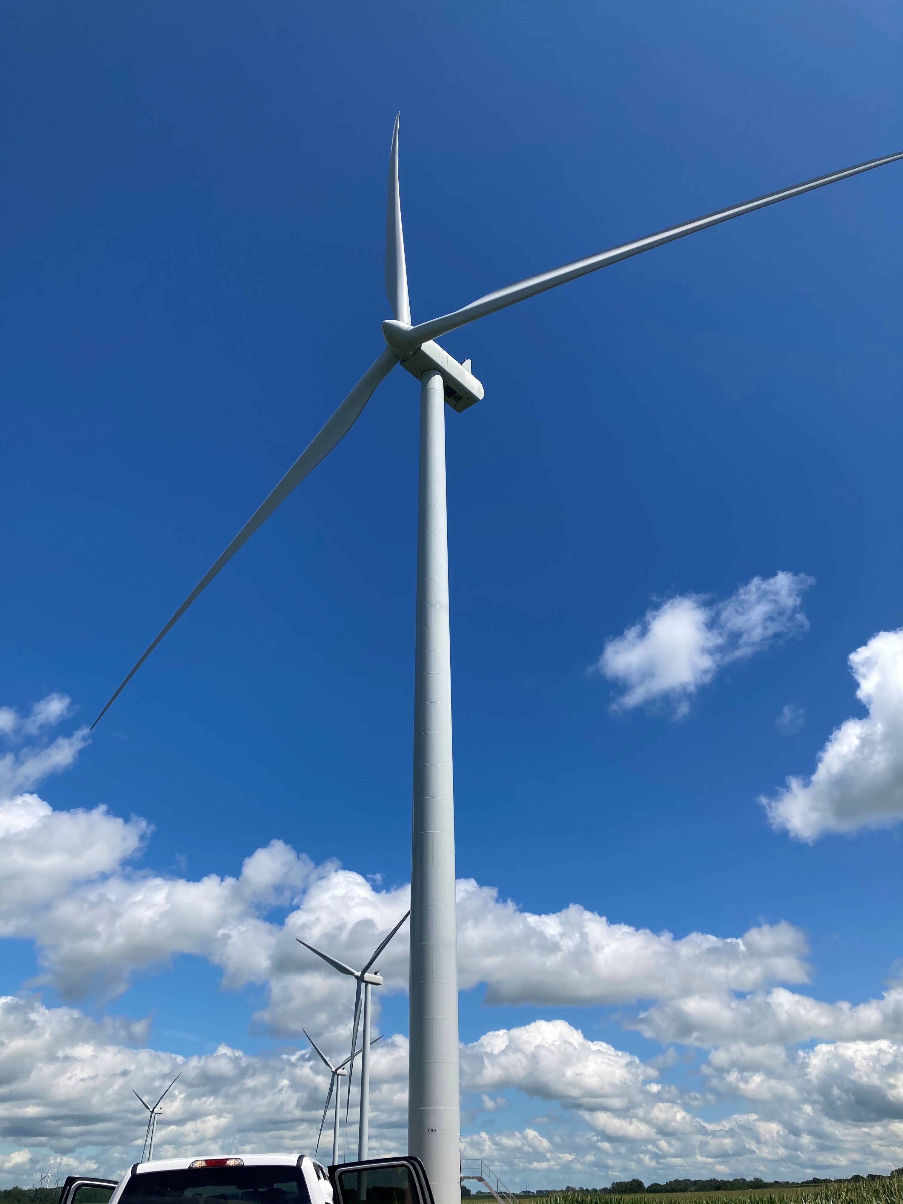 Wind Turbine in front of blue sky filled with clouds