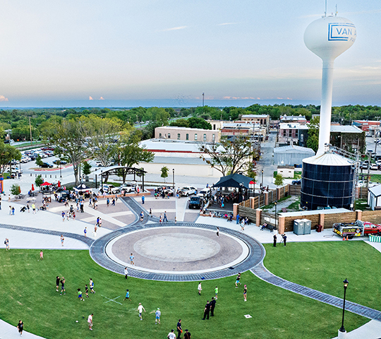 Aerial shot of a park. park has a large concrete circle walking path in the middle.