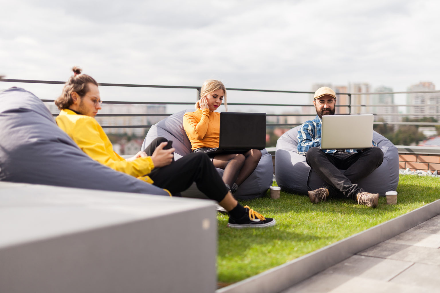 3 people working outside on a rooftop