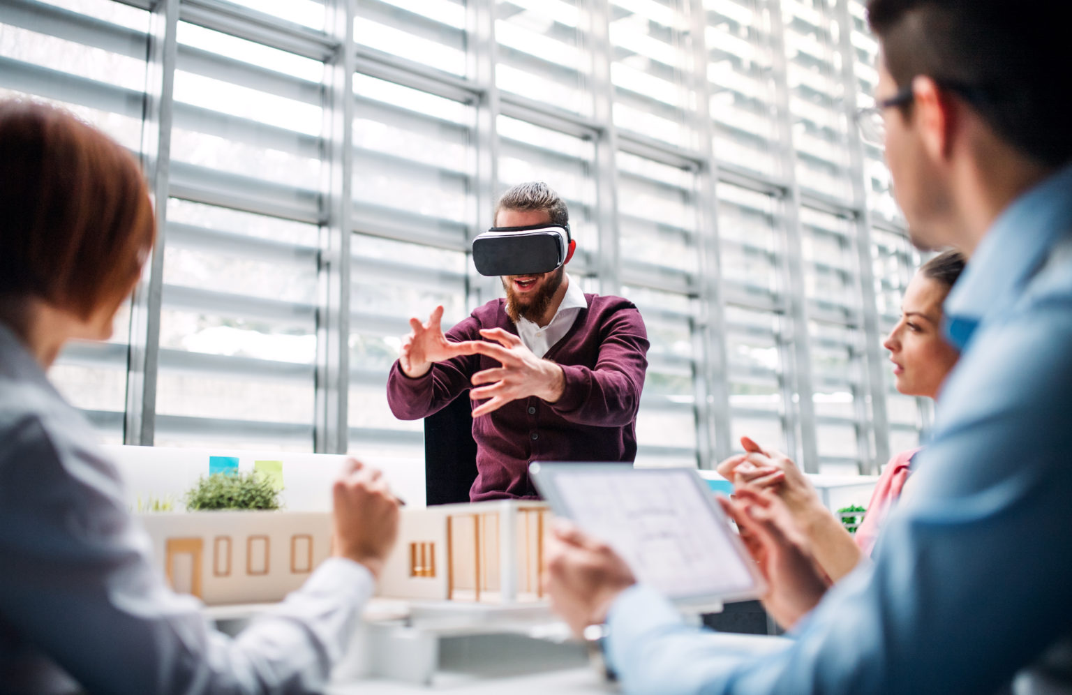 a man using a VR headset with coworkers