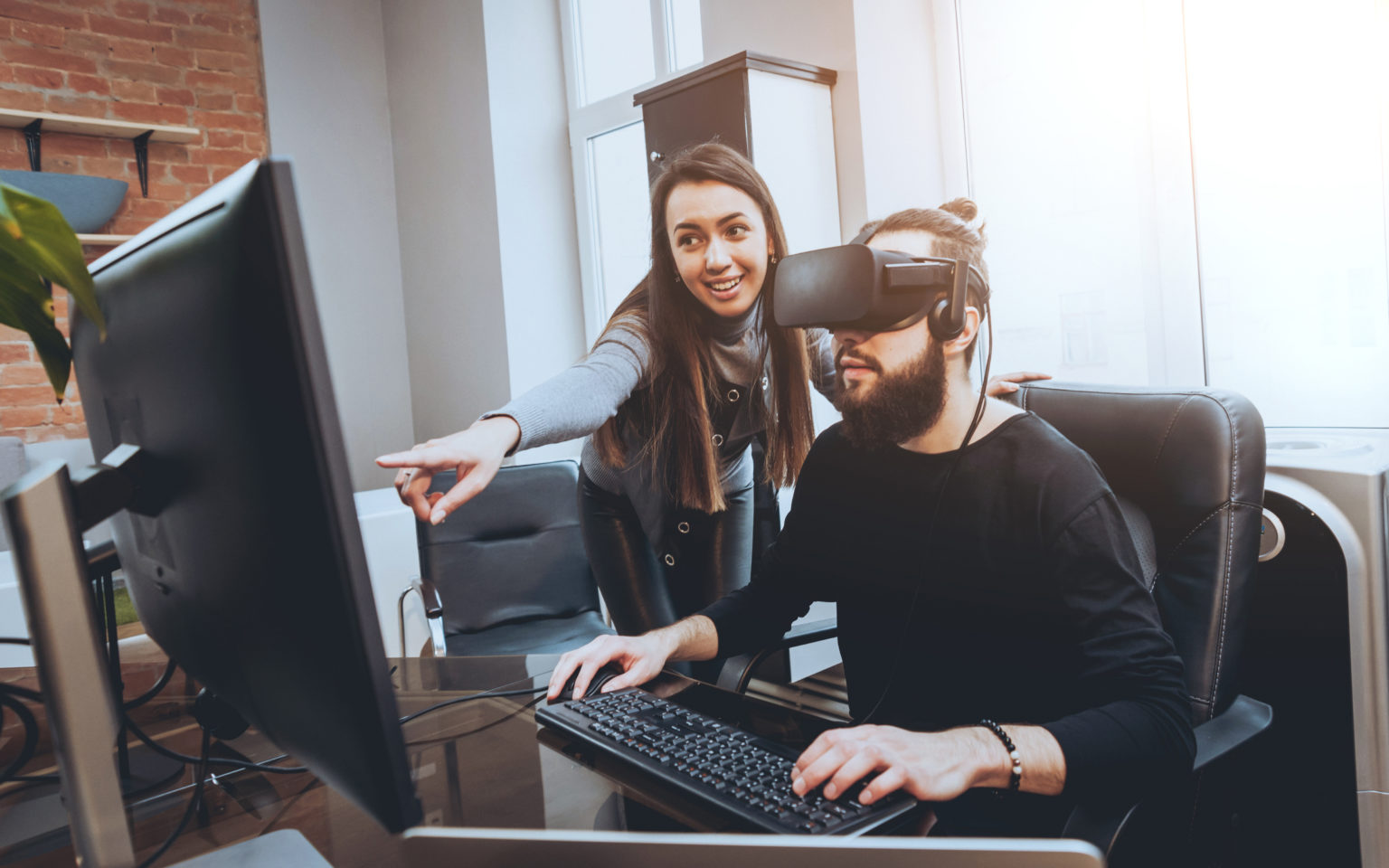 man wearing a VR headset while working on a computer