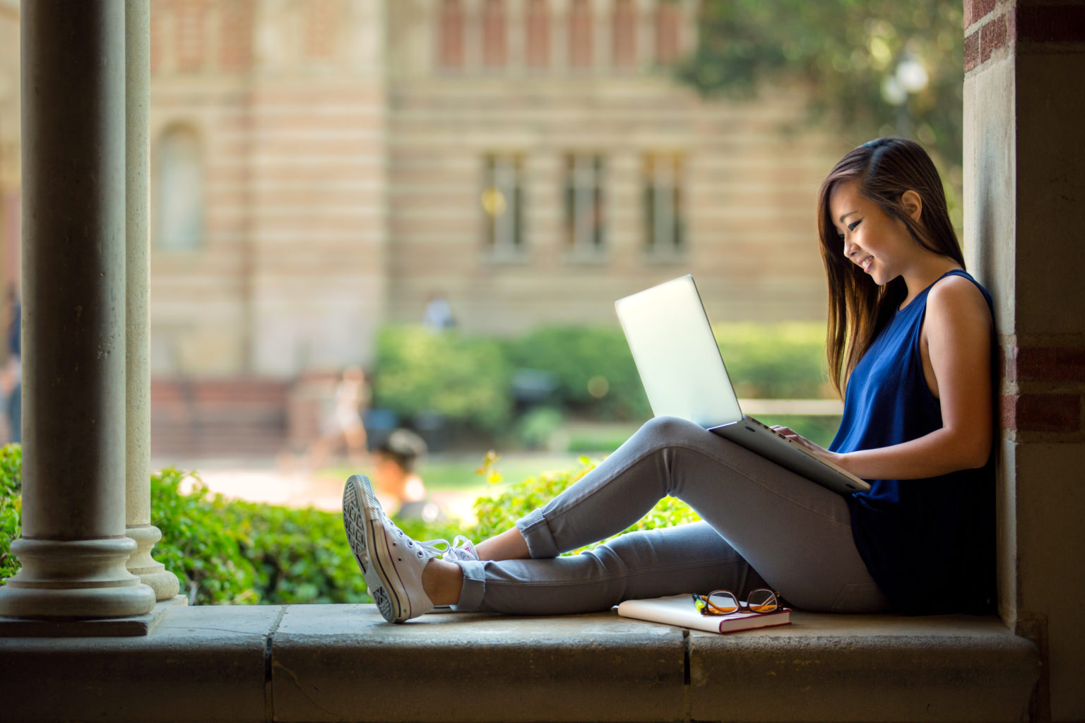 women working on a laptop outside